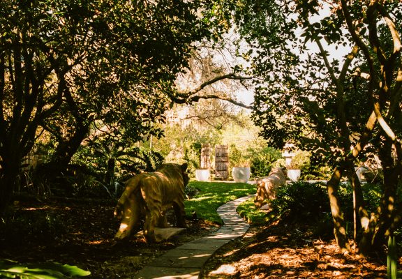 Lush green exterior of Center Street with sculptures.